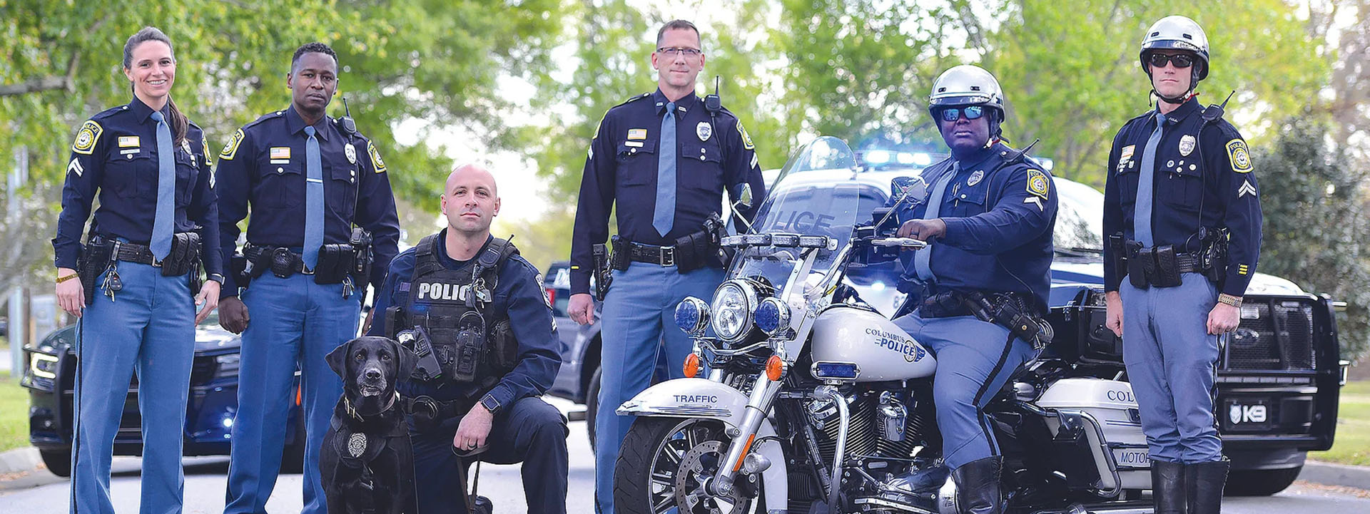 Police officers with patrol cars in the background
